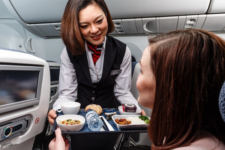 British Airways' new World Traveller catering - cabin crew serve main meal on flights to the Far East